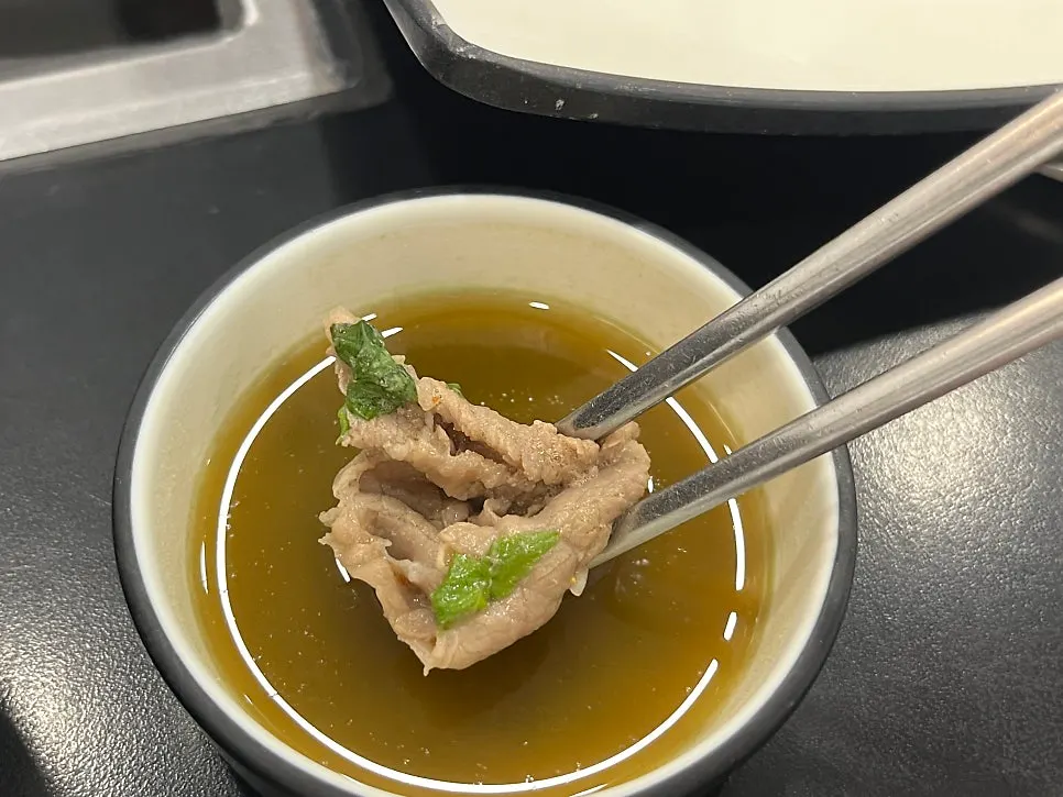 Shabu-shabu meat cooked in the broth and lifted out