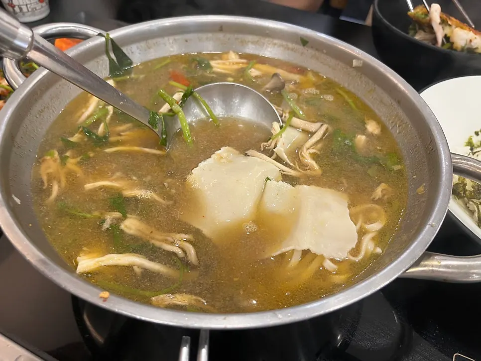 Table spread with seafood pajeon alongside shabu-shabu