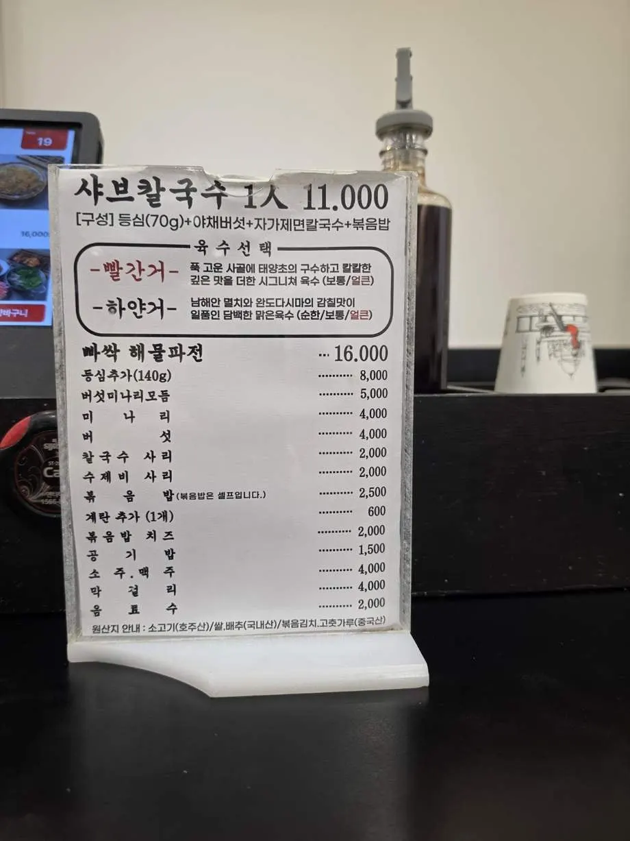 Menu board listing the ₩11,000 per person shabu kalguksu