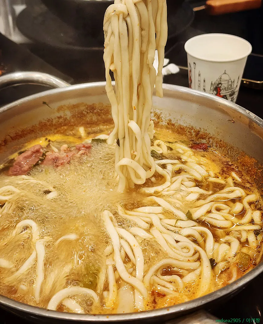 Kalguksu noodles added to the boiling broth
