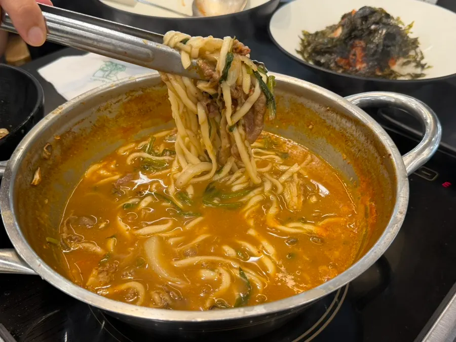 얼큰한 국물에서 끓고 있는 칼국수 면