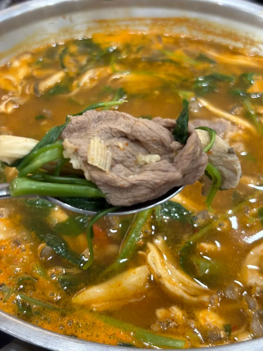 Meat cooked in the broth with mushrooms and minari