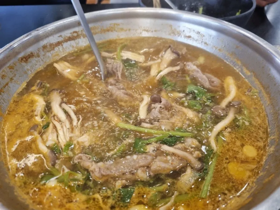 House-made kalguksu noodles added to the now-richer broth