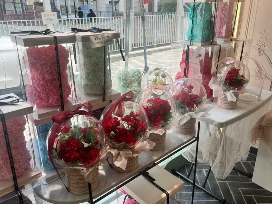 Display shelf with a variety of flowers and gift items