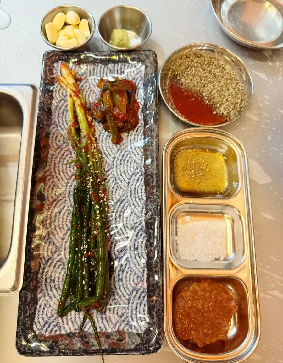 불판 위에 올려진 미나리와 김치
