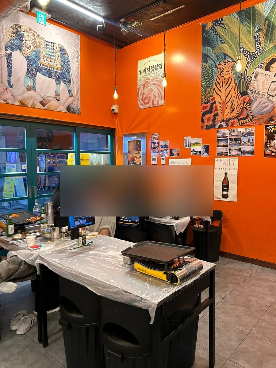 Orange wallpaper wall with posters, giving a street tent bar feel