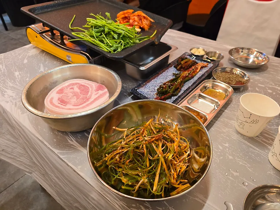 A full spread with a mountain of shredded green onion and basic sides