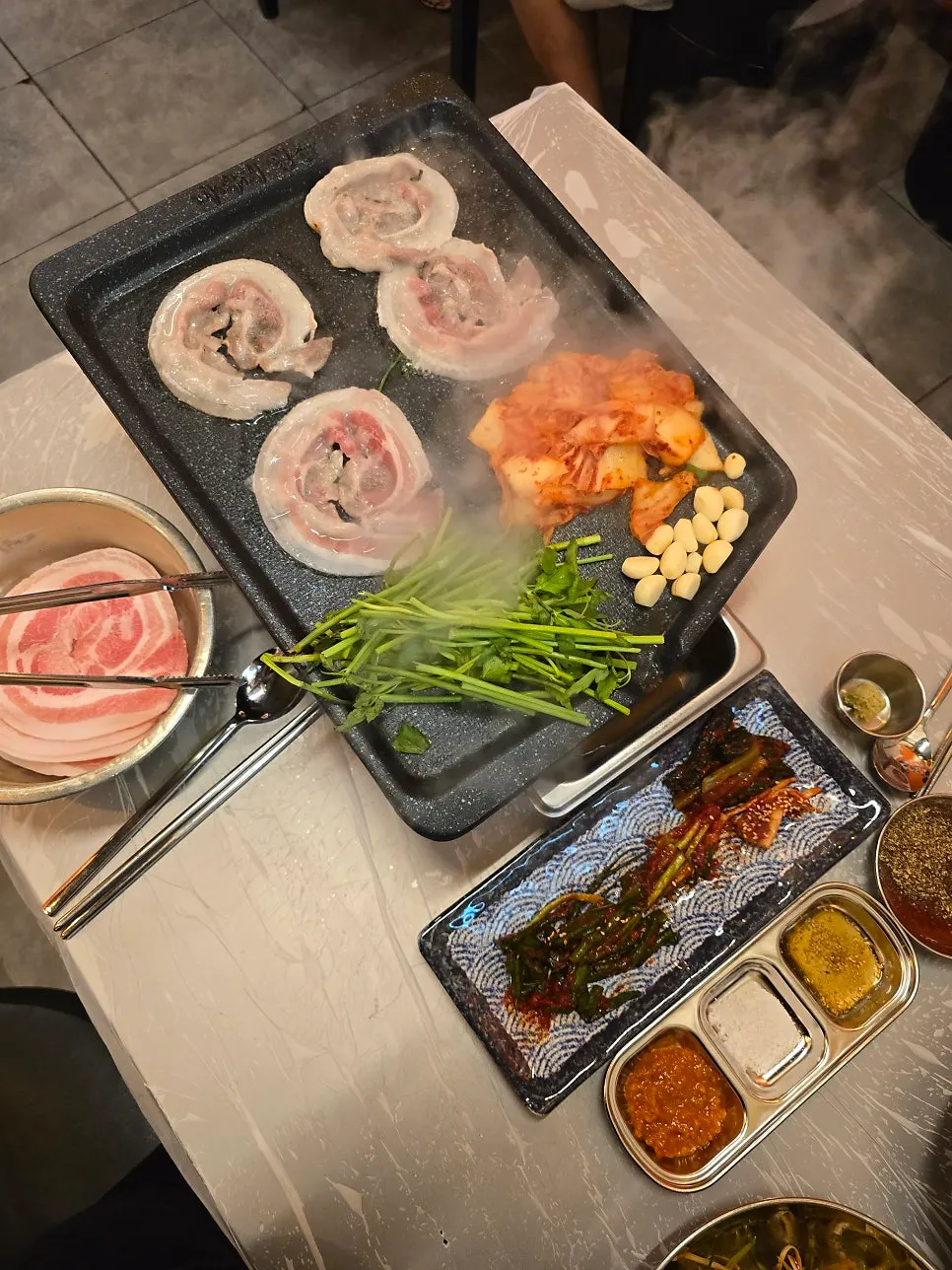 Frozen pork belly grilling on the griddle