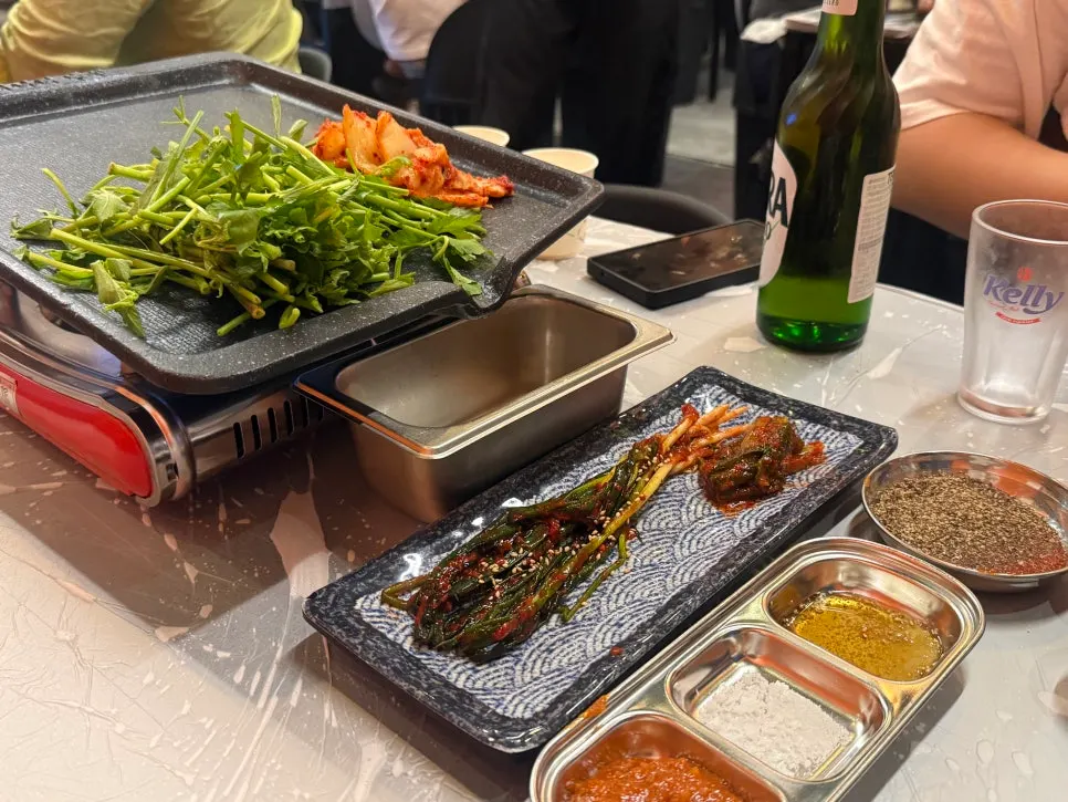 A plate of sauces, green onion kimchi, and green onion salad side dishes