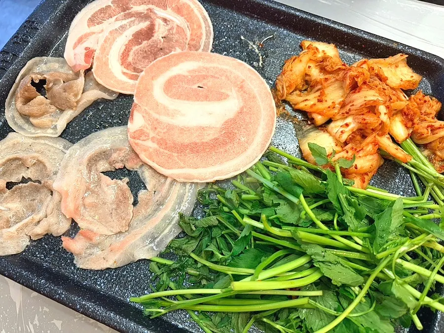 Minari and kimchi placed at the edge of the grill