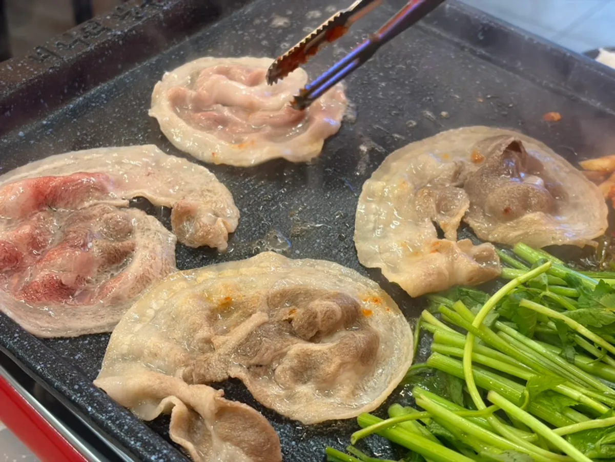 Frozen pork belly cooking on the grill