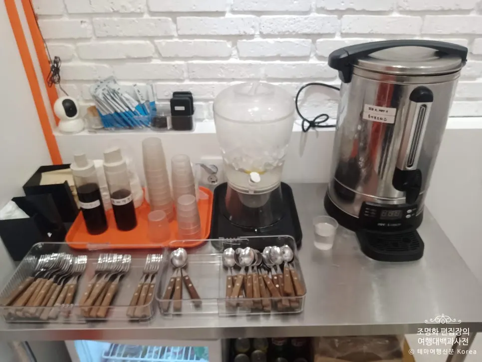 Self-serve bar with forks, spoons, and two kinds of sauce