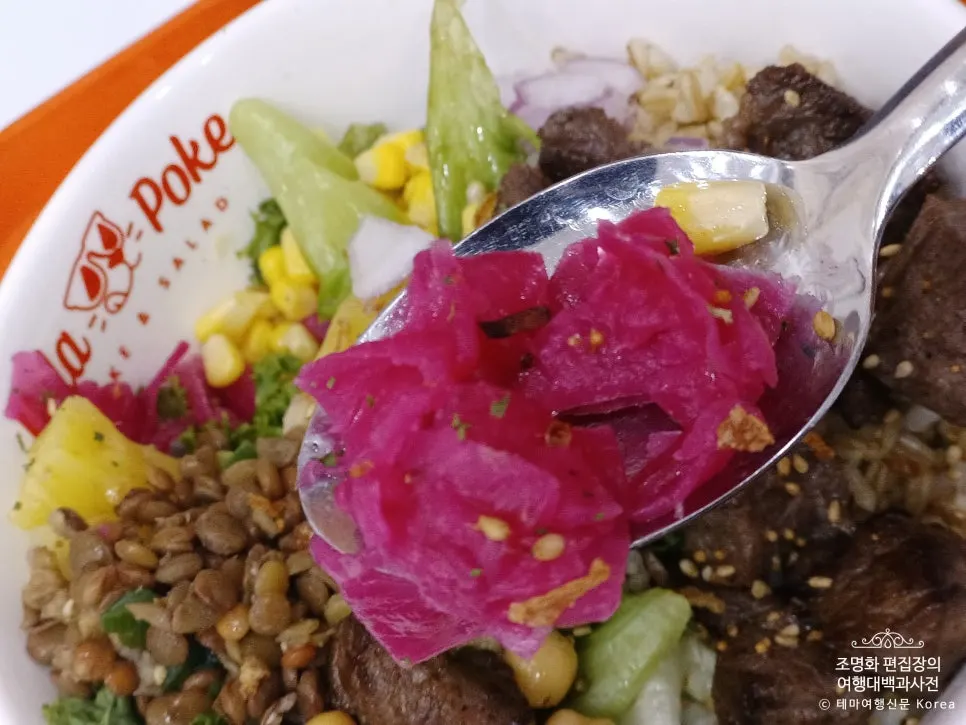 A bite of poke showing lentils and chickpeas
