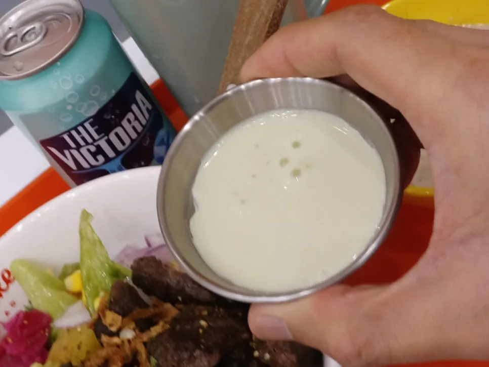 Drizzling wasabi-scented sauce onto the poke bowl