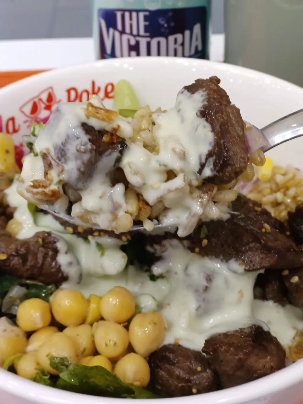 A spoonful of the mixed steak poke lifted up