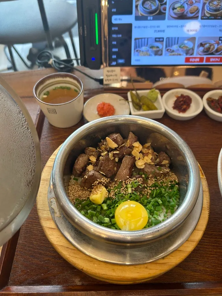 Steak pot rice topped with garlic chips and egg yolk