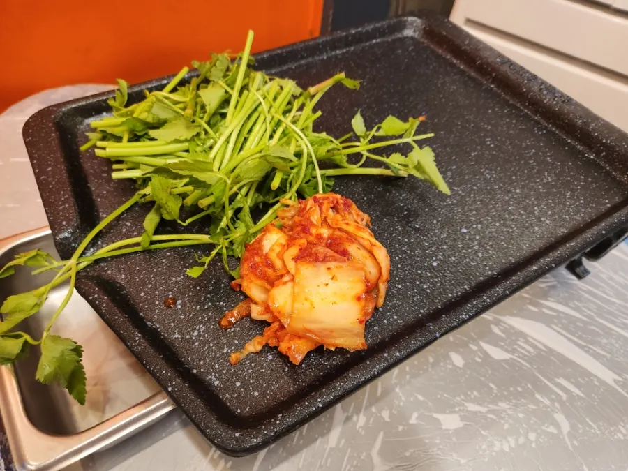 Minari and kimchi placed on the grill