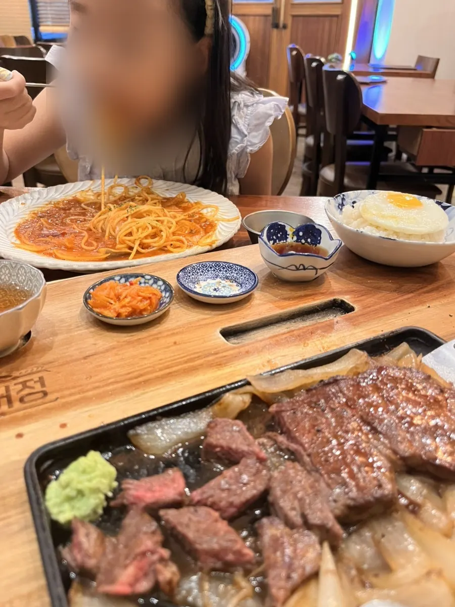 ステーキとパスタを交互に食べる夕食の様子