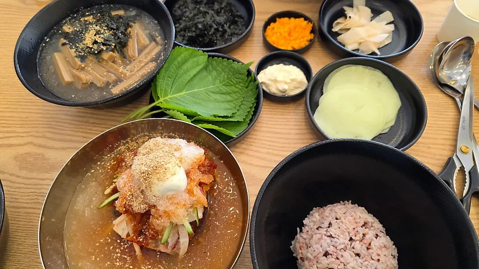 Table set with jjukkumi-saeu and naengmyeon