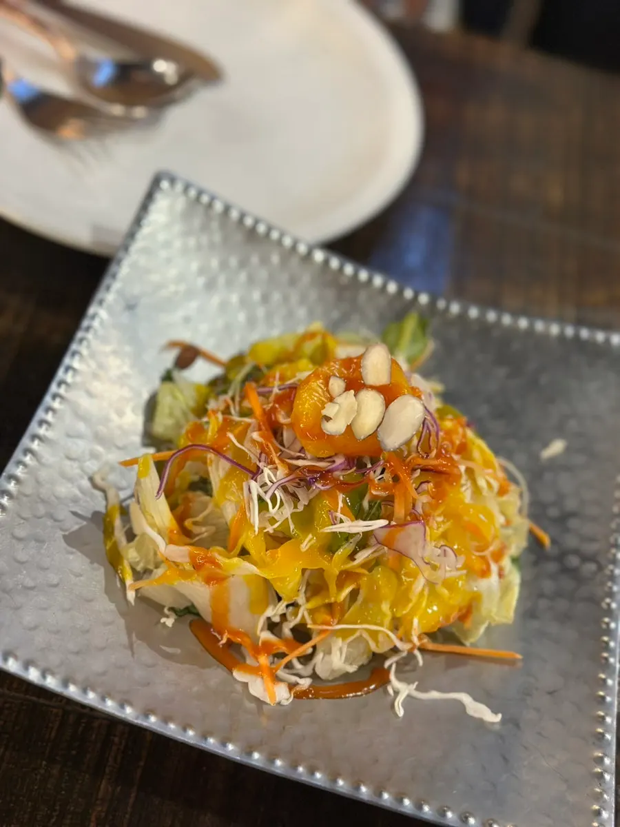 Green salad topped with tangerine