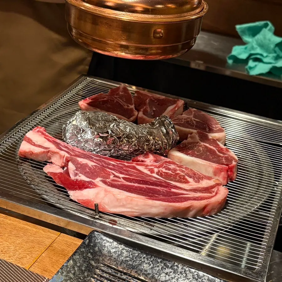 Staff grilling lamb on the tabletop grill