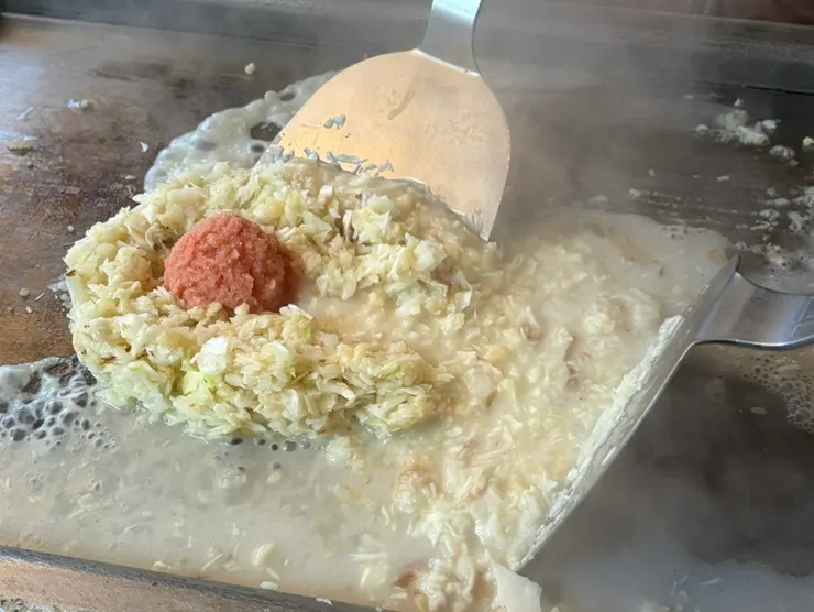 Mentaiko placed in the center with broth being poured in during cooking