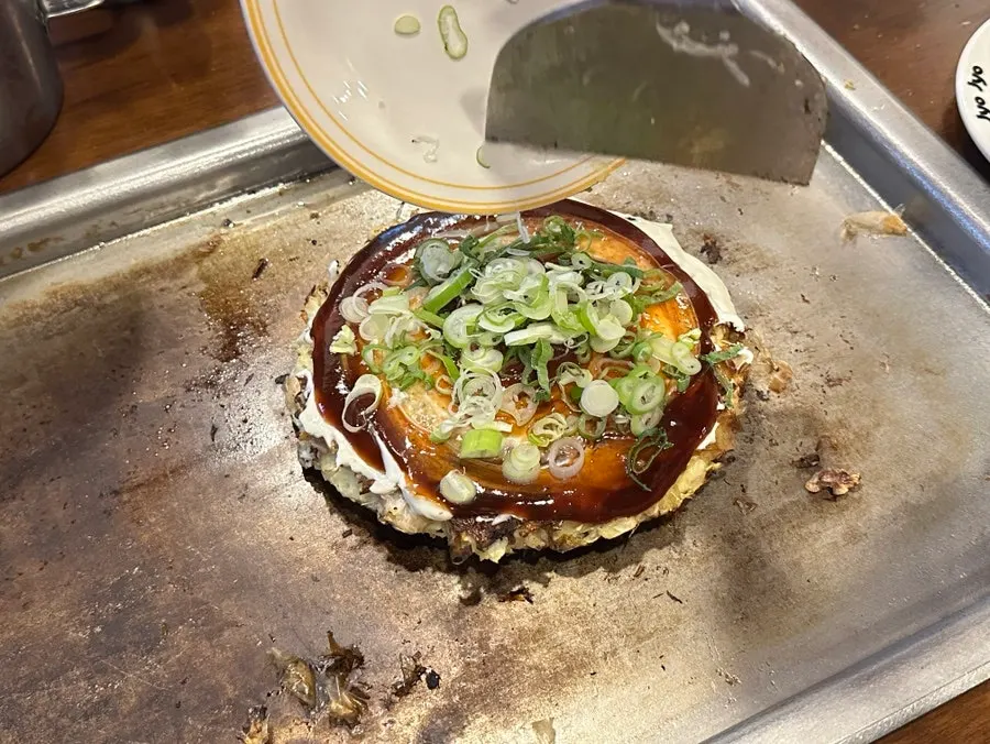 Okonomiyaki finished with a scallion topping