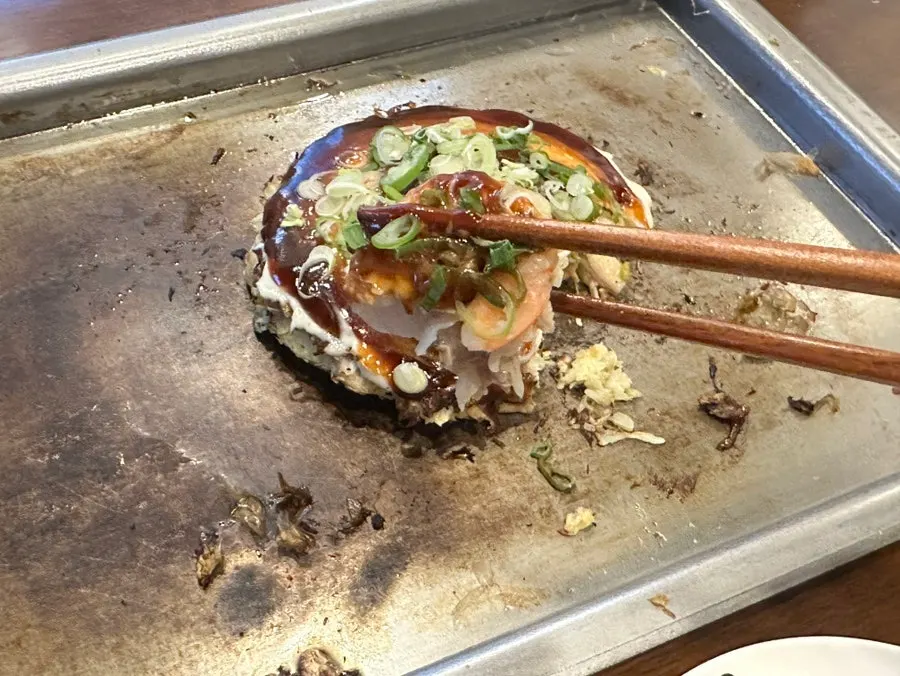 Okonomiyaki served with spicy sauce on the side