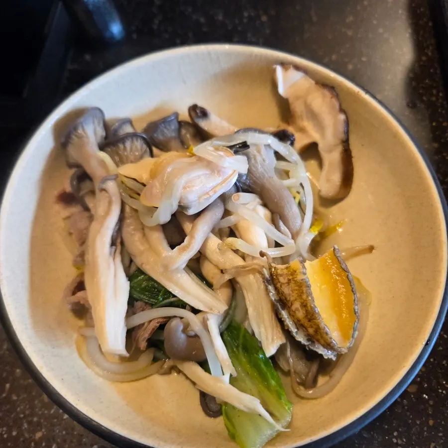 A plate of cooked clams and vegetables