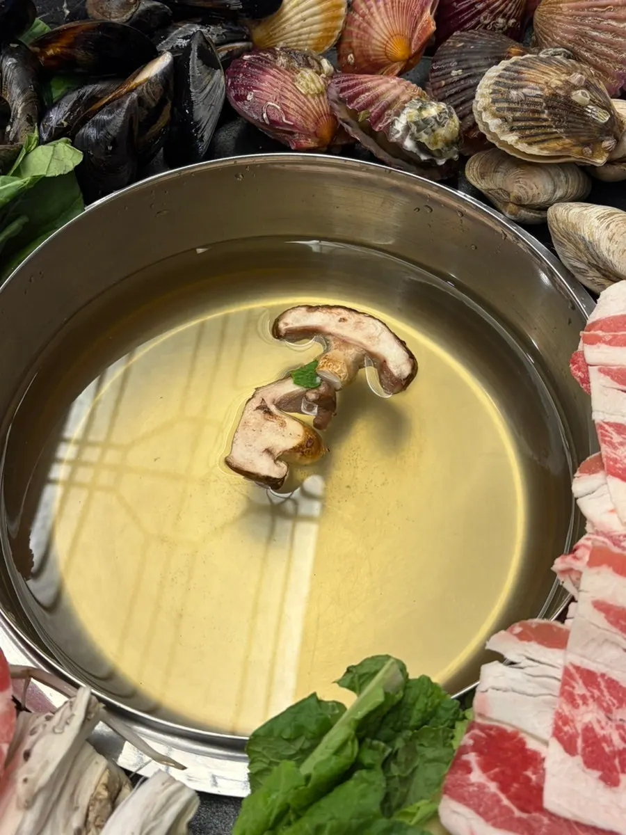 Pot of Palmi clam shabu kalguksu filled with clams and abalone