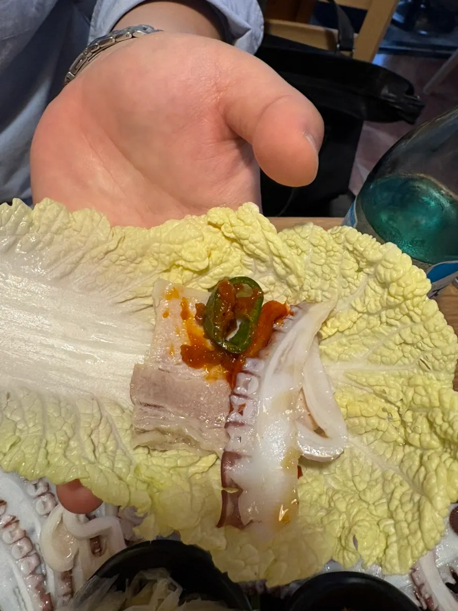 백김치에 올린 보쌈과 문어숙회 한 쌈