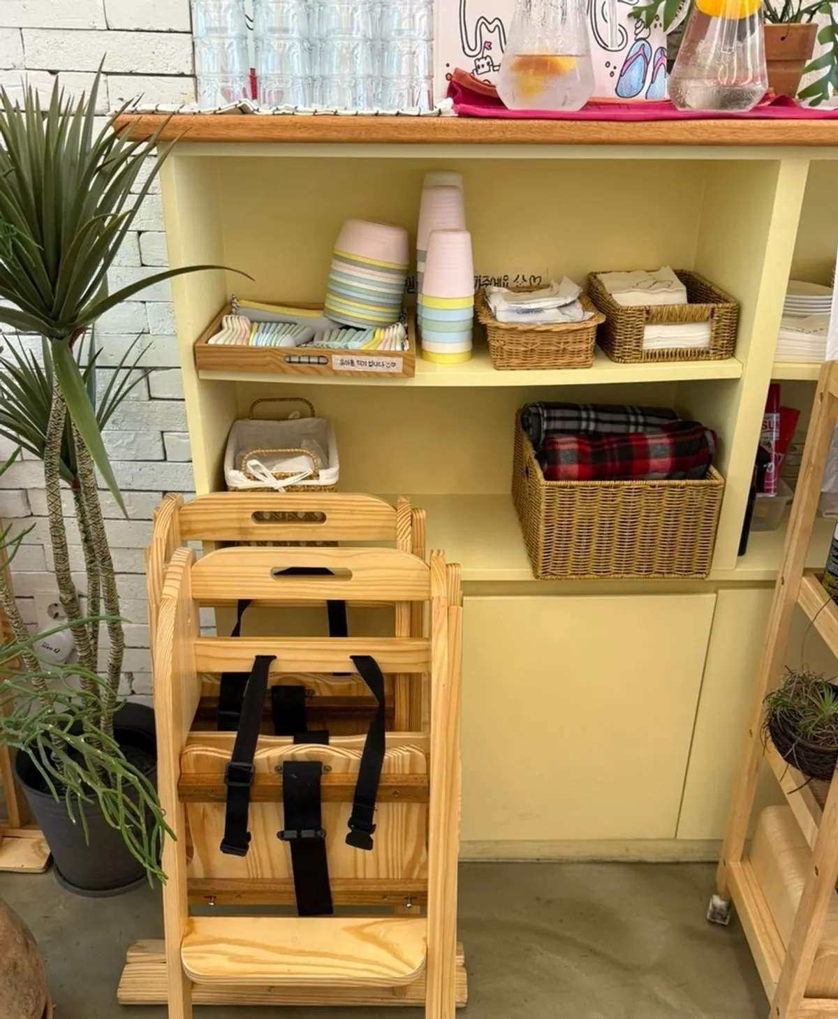 Corner of the store set up with kids' tableware and a baby chair