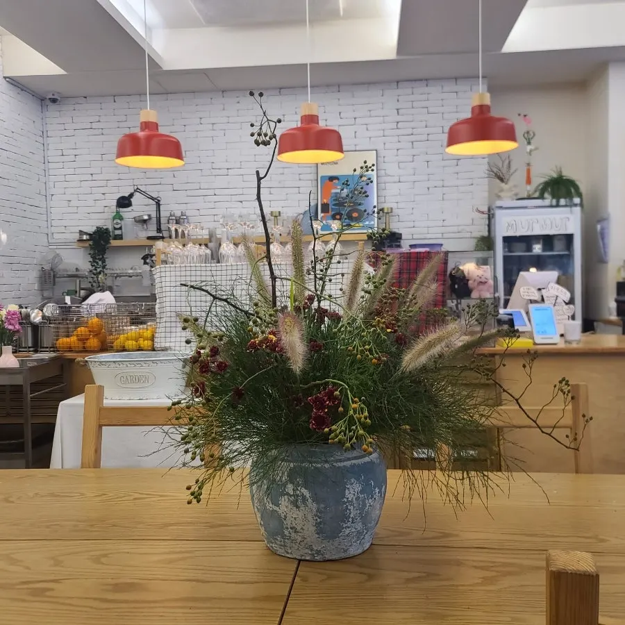 A vase of fresh flowers and tableware on the table