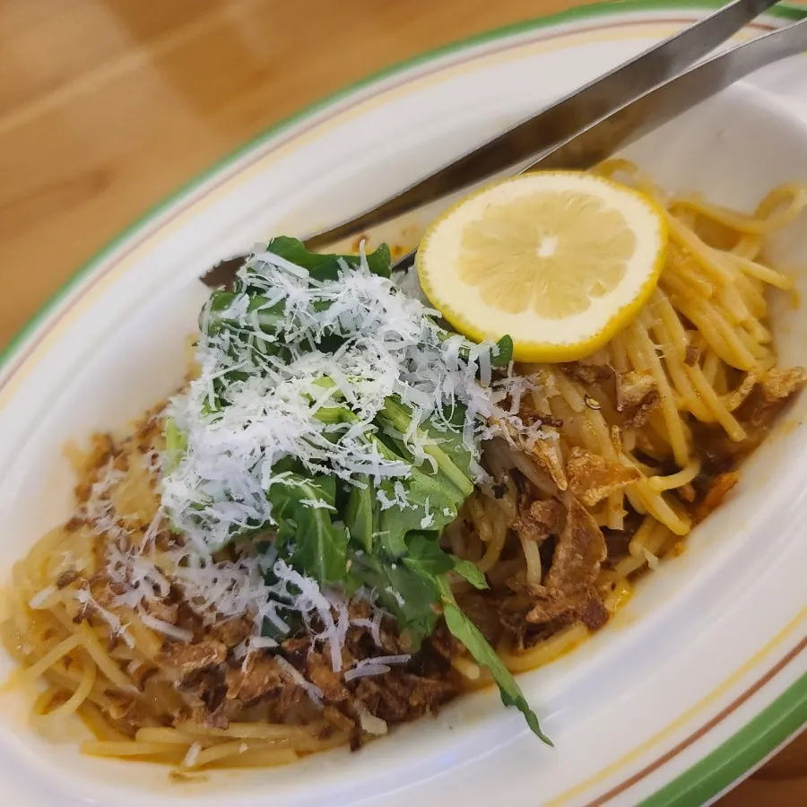 Spicy Lemon Anchovy Pasta topped with arugula and fresh lemon