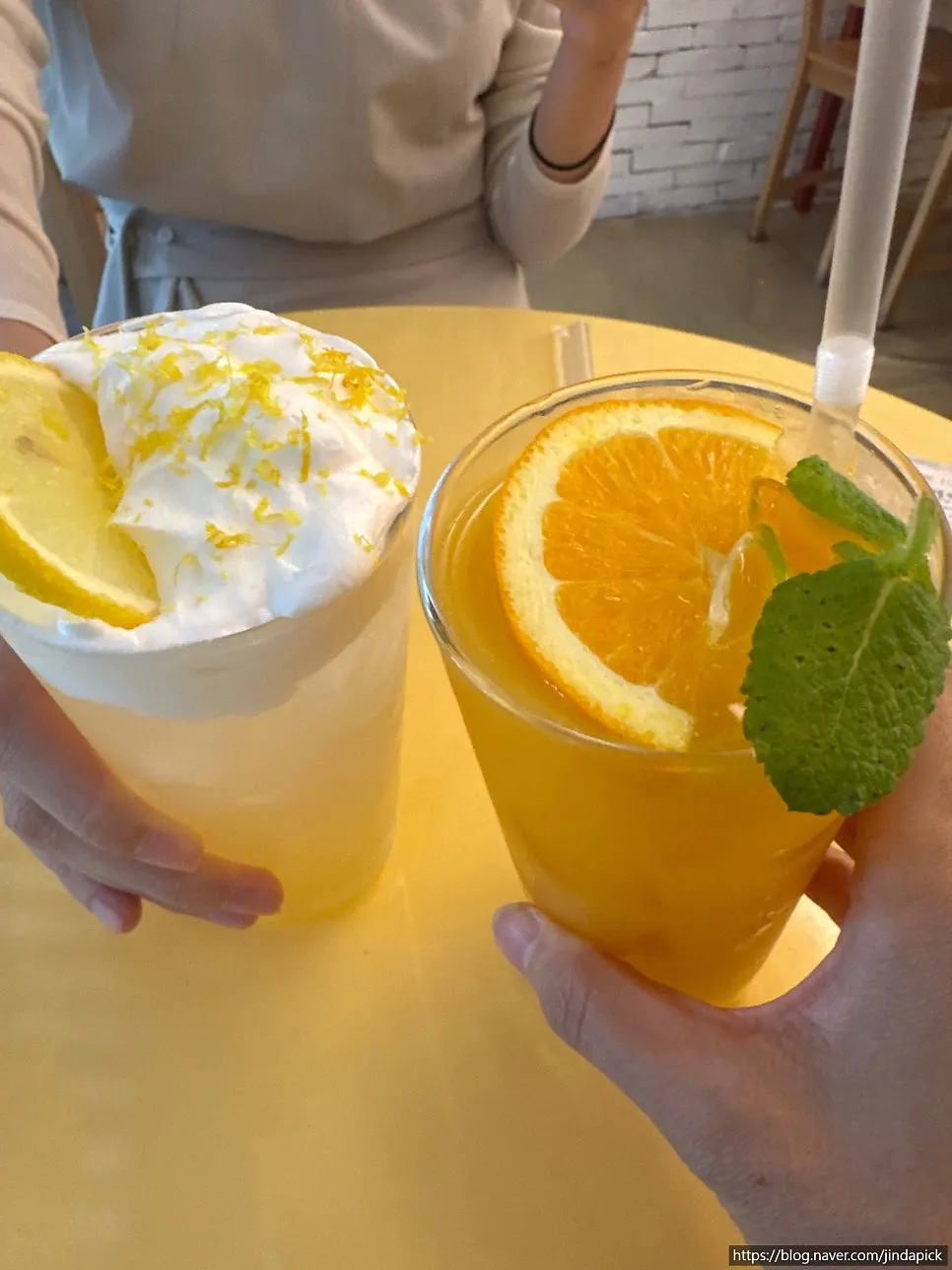 Two glasses: lemon cream tea and orange juice
