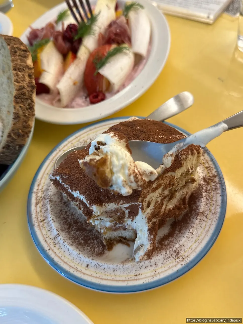 Tiramisu with a spoon revealing the cream layer