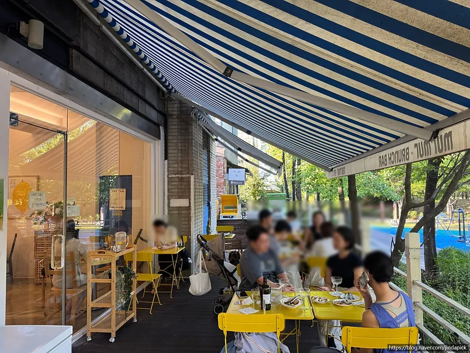 Yellow-table terrace seating facing the park