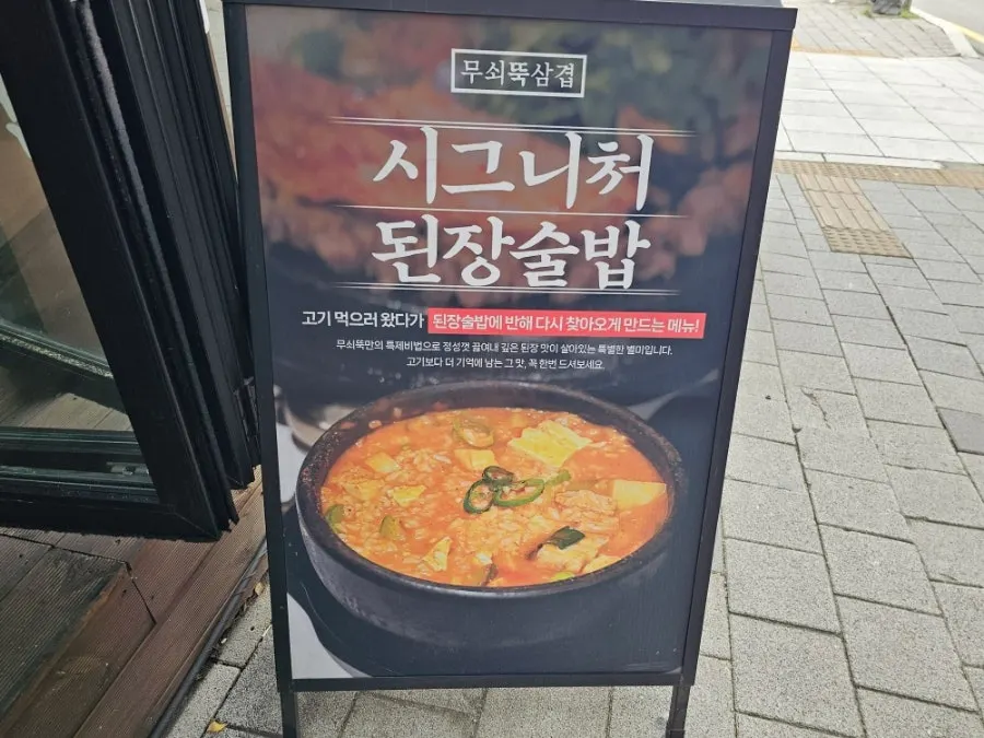 A pan of pork belly served with minari and tofu