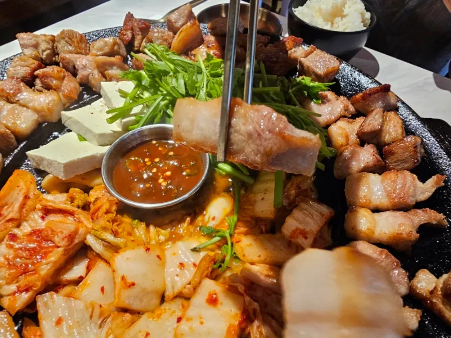 Simmering meljeot sauce beside grilling pork belly