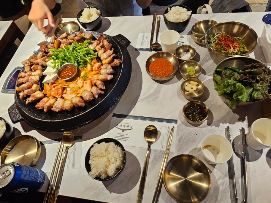 Side dishes of lettuce, pickled scallion, and seasoned chili