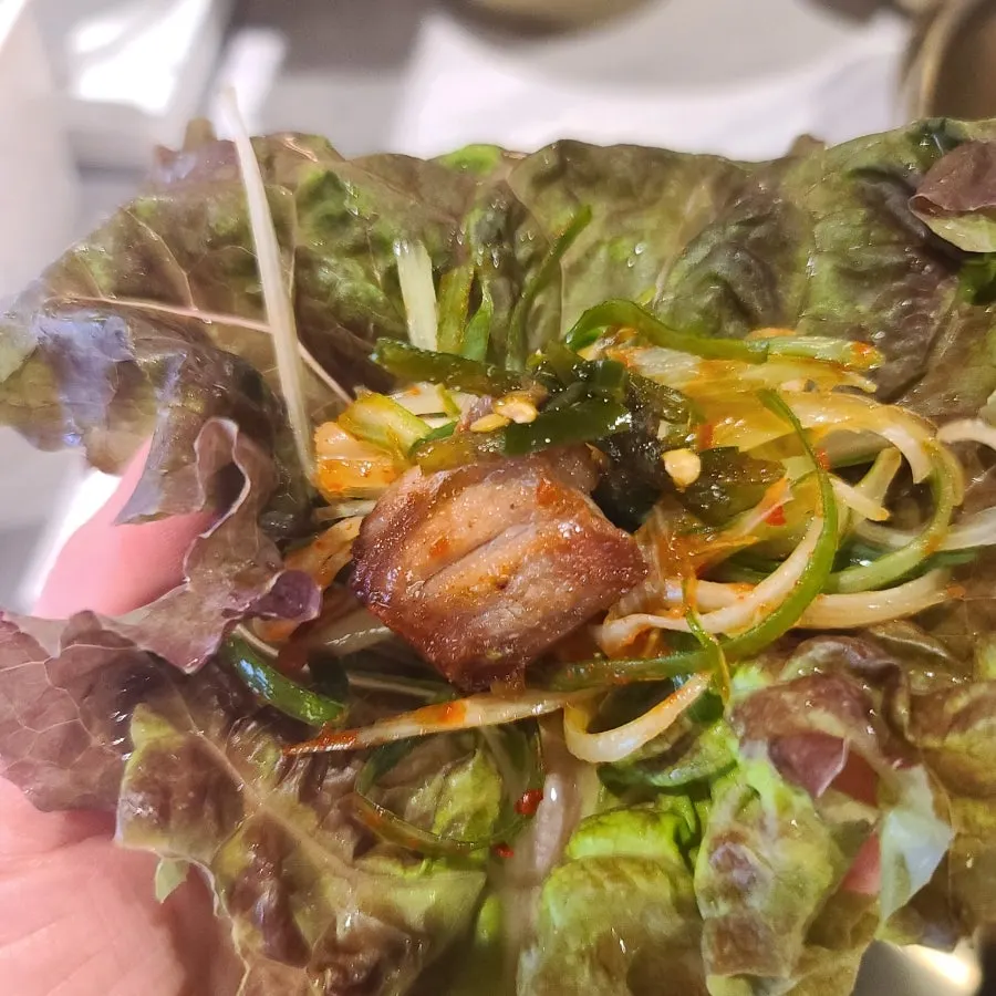 A piece of meat paired with grilled kimchi and tofu
