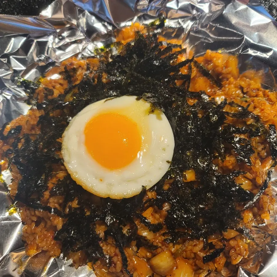 Kimchi fried rice mixed with a burst egg yolk