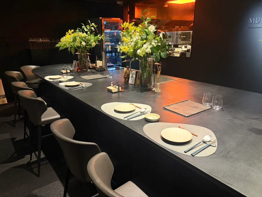 MUSEO's long bar table with a floral arrangement