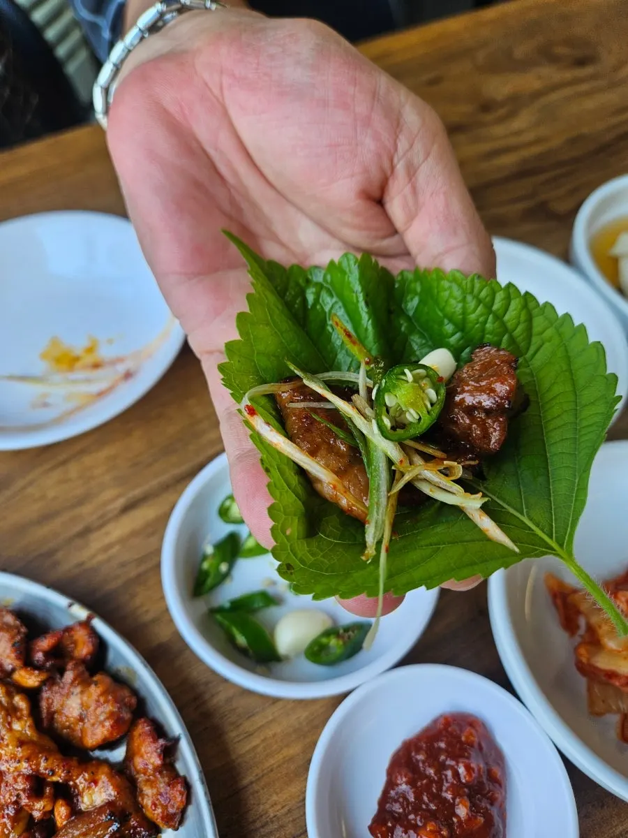 Side dishes at Ttukbangjip including pickled onion, cucumber, and sautéed zucchini