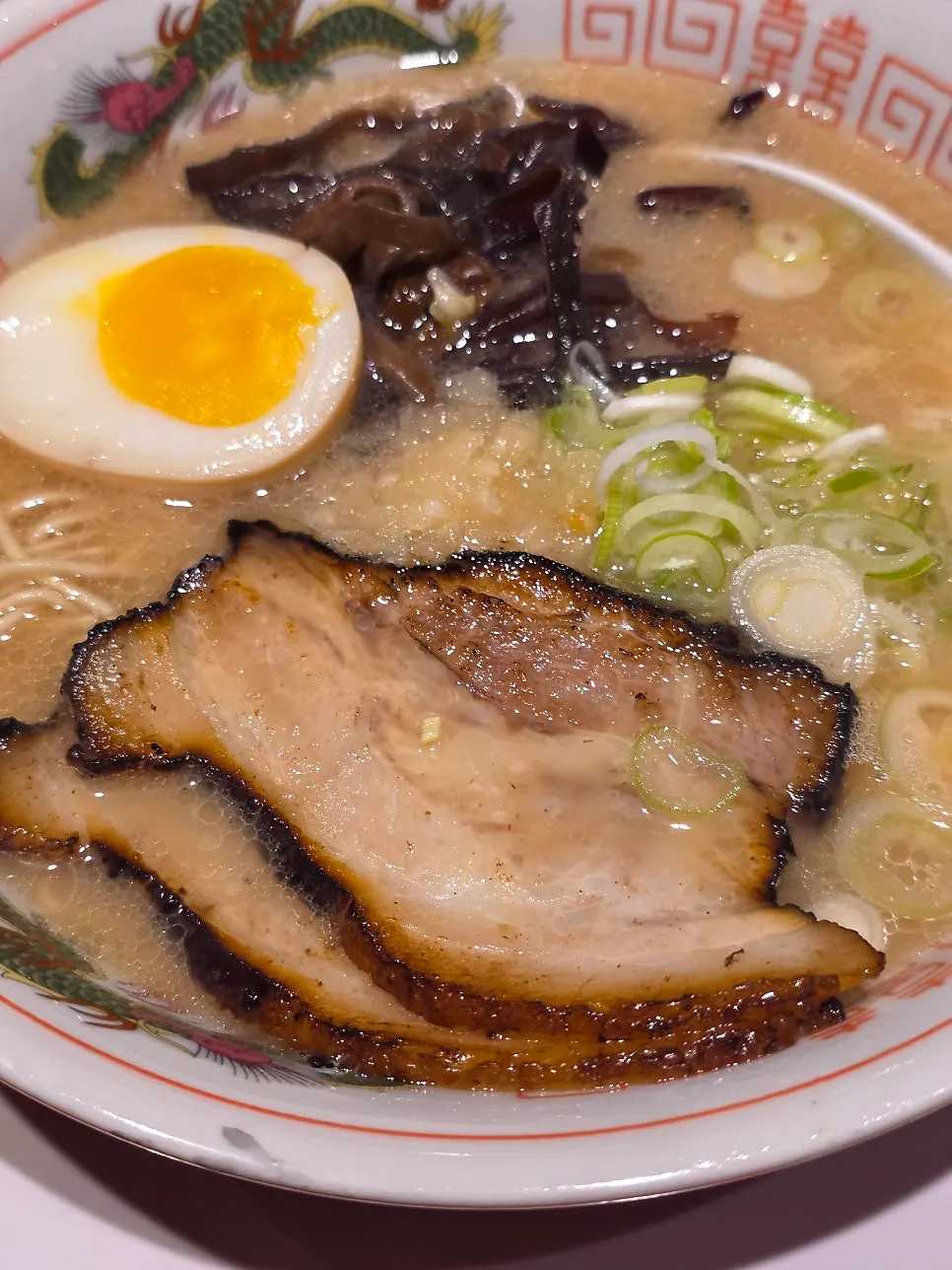 Two slices of pork-belly chashu, soft-boiled egg, and wood ear toppings