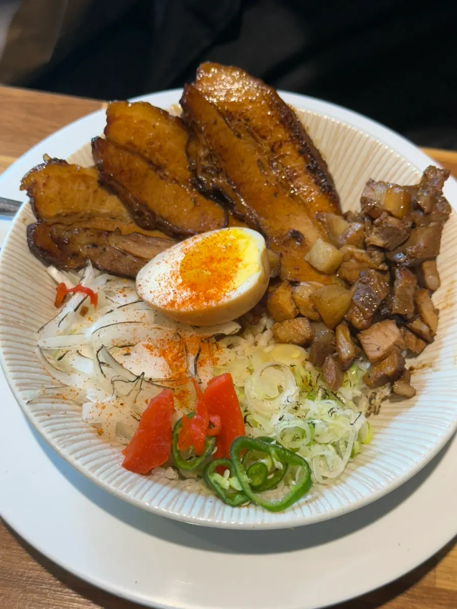 Close-up of abura soba loaded with chashu and cubed meat