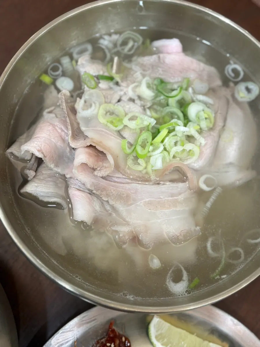 Clear pork gomtang broth piled with scallions