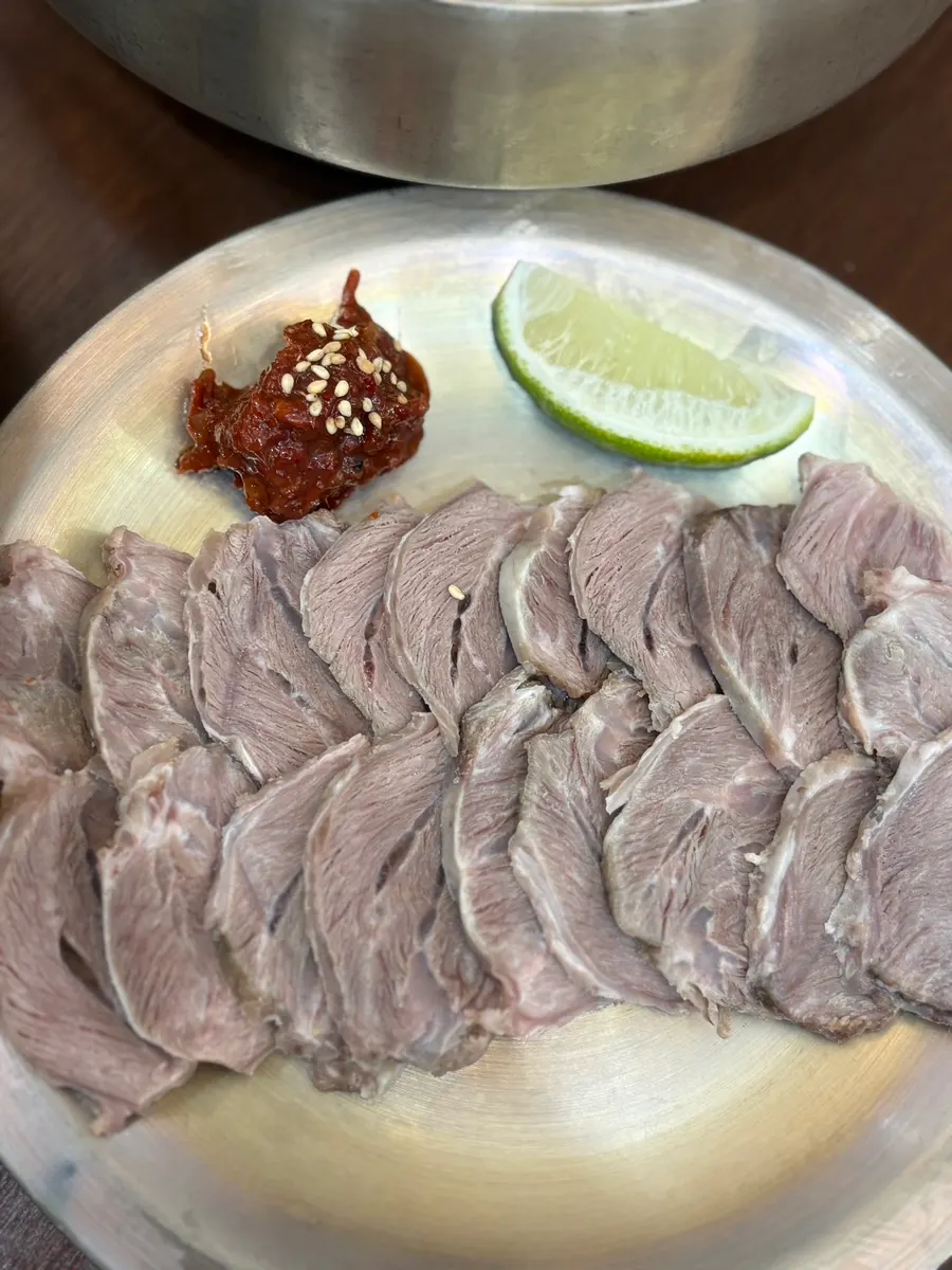 A spoonful of pork gomtang broth and meat