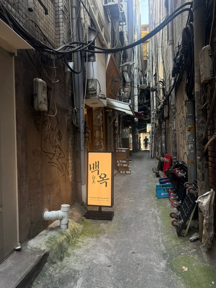 Baekok standing sign farther into the alley