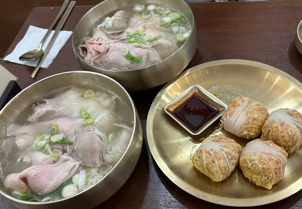 Table spread of pork gomtang and cabbage dumplings